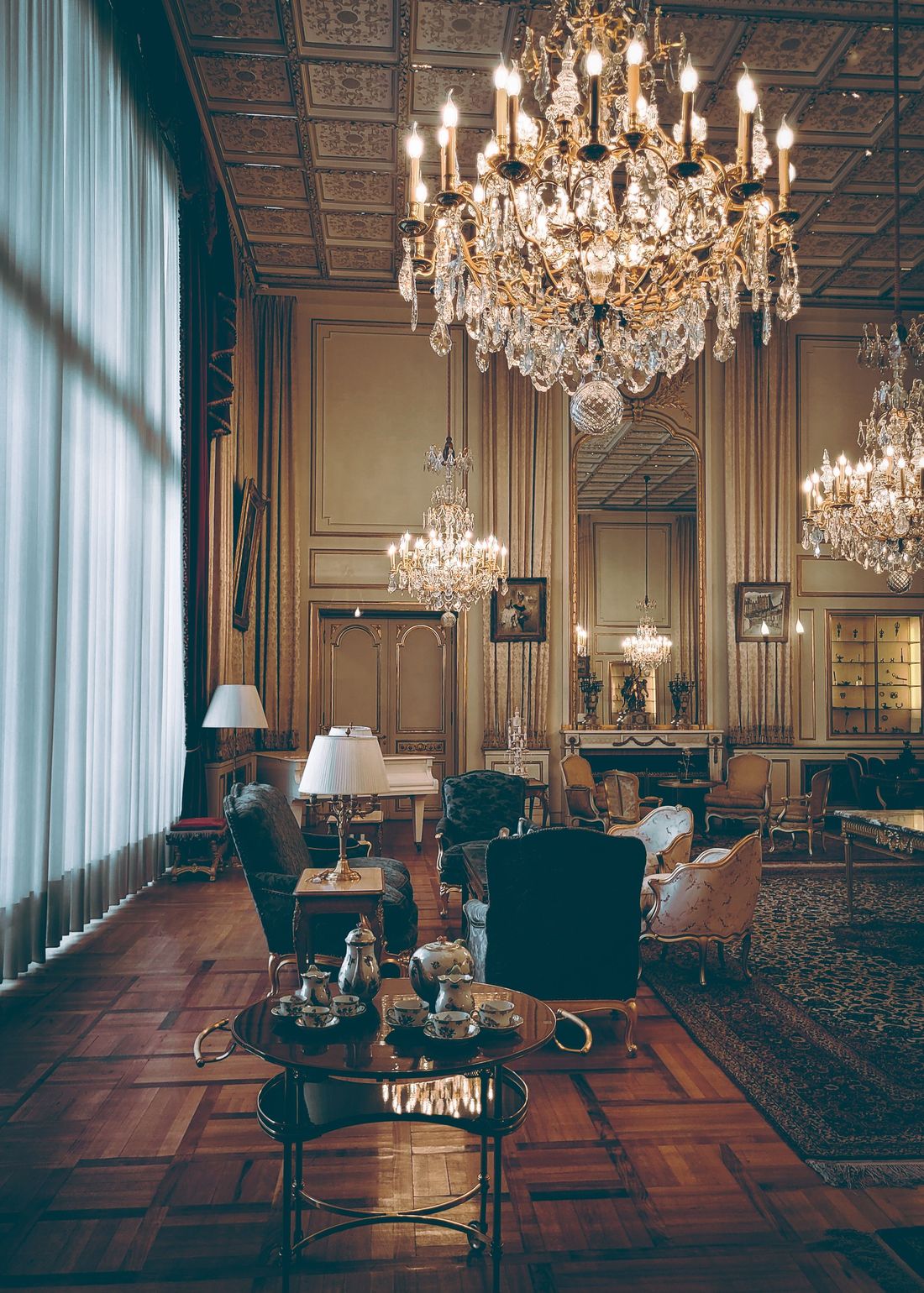 Sfeerbeeld van een verzorgde, klassieke woonkamer met kroonluchters